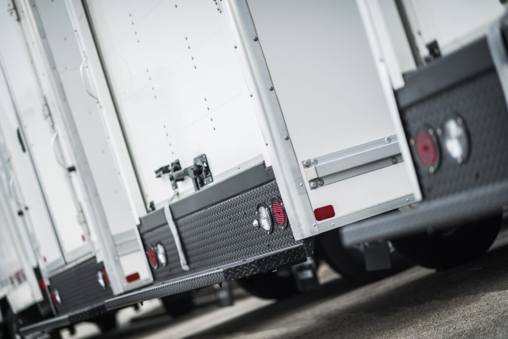 Commercial Cargo Trucks Fleet Close Up. Delivery Vehicles in a Row. Transportation Industry Theme.